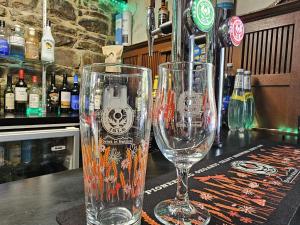 two empty wine glasses sitting on top of a bar at River Black Water inn in Garve