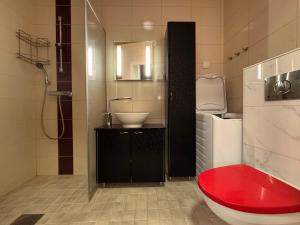 a bathroom with a red tub and a sink at Kotimaailma - Saunallinen kolmio in Kokkola