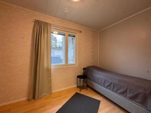 a bedroom with a bed and a window at Kotimaailma - Saunallinen kolmio in Kokkola