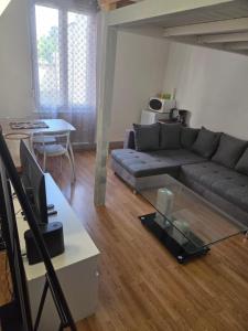 a living room with a couch and a table at Spacieux studio prestige in Bischheim