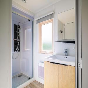 a bathroom with a sink and a mirror at Camping Le Paradis Médoc in Saint-Laurent-de-Médoc