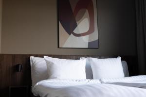 a hotel room with two beds and a painting on the wall at Aspenäs Herrgård in Lerum