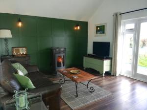 a living room with a couch and a fireplace at Charming Countryside Chalet in Mégrit