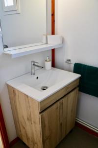 a bathroom with a white sink and a mirror at Chalet Au Petit Bonheur Piscine & Domaine calme in Rivières +22 photos