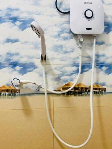 a blow dryer hanging on a wall with a beach at Baywings Rooms in Arugam Bay