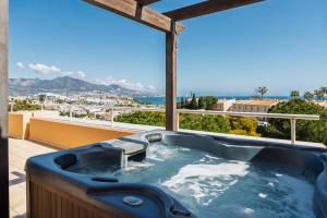 a jacuzzi tub on a balcony with a view at Malibu Mansions by the beach by ALFRESCO STAYS in Mijas Costa