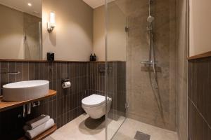 a bathroom with a shower and a toilet and a sink at Aspenäs Herrgård in Lerum +33 photos