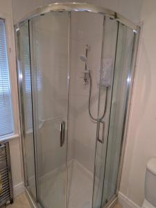 a shower with a glass door in a bathroom at Lough View in Rostrevor +30 photos