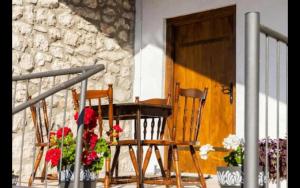two chairs sitting on a porch next to a door at Old House Piperi in Podgorica