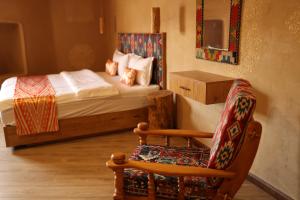 a bedroom with a bed and a chair and a chair at Hotel Old Heritage in Tashkent +42 photos