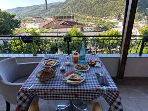 a table with plates of food on top of a balcony at Villa Aurel in Berat +36 photos