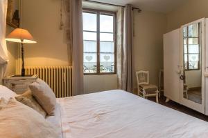 a bedroom with a large white bed and a window at La Palette Fleurie in Laignes