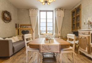 a living room with a table and chairs and a couch at La Palette Fleurie in Laignes