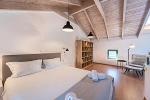 a bedroom with a large white bed and a chair at Twin Olive Villas in RhodesRhodes