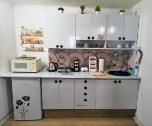 a small kitchen with white cabinets and a microwave at Pension Archa in Znojmo +37 photos