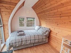 a bedroom with a bed in a room with wooden walls at Cosy Cocoon in Malton