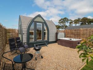 a small greenhouse with a tub and chairs in a yard at Cosy Cocoon in Malton