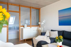 a living room with a blue couch and a bedroom at Sonnenkoje in Fehmarn