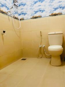 a bathroom with a toilet and a shower at Baywings Rooms in Arugam Bay