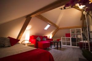 ein Zimmer mit einem Bett und einer roten Couch auf dem Dachboden in der Unterkunft Morges House in Morges