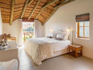 a bedroom with a large white bed and a window at Tides River Lodge in Malgas