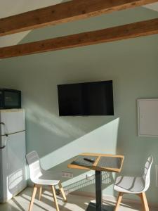 a room with a table and two chairs and a tv at Rever la Saône in Rigny