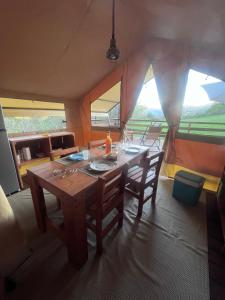 a dining room with a wooden table and chairs at Domaine Solio - Lodge isolée, nature, animaux in Satillieu