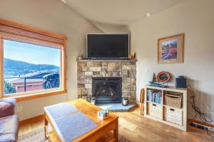 a living room with a fireplace and a flat screen tv at River Scene 30 Night Minimum in White Salmon