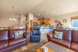a living room with leather furniture and a kitchen at River Scene 30 Night Minimum in White Salmon