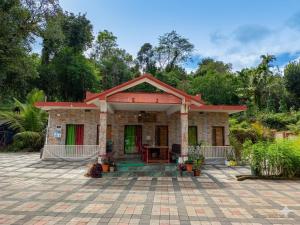 a small house with a pavilion on a patio at Belandoor Nature Nest in Sringeri