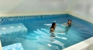 two people are swimming in a swimming pool at Marina Luxury in Torrevieja