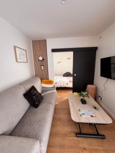 a living room with a couch and a coffee table at La parenthèse boisée in La Chapelle-en-Serval