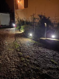 a street with lights on the side of a building at La parenthèse boisée in La Chapelle-en-Serval