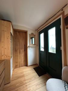a room with a black door and wooden floors at Zirkuswagen im Gutshof in Lutterberg +7 photos