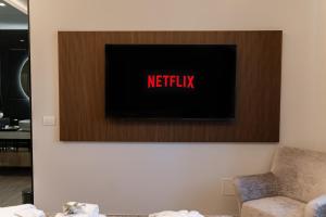 a television on a wall with the words netflix at Easter Suites Luxury - Signature Stays in Monopoli in Monopoli