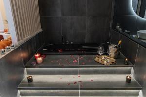 a bathroom with a pool with red candles on the floor at Easter Suites Luxury - Signature Stays in Monopoli in Monopoli +198 photos
