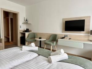 a hotel room with a bed and a flat screen tv at Apartman Hotel in Bük