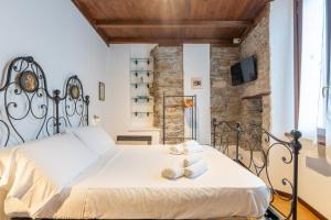 a bedroom with a bed with towels on it at Historic Borgo Lake Como Campidoglio 5 in Lenno