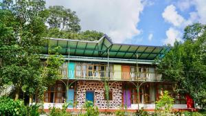 a colorful house with a balcony on top of it at Hotel YAN Residency Bhimtal - Nainital in Bhīm Tāl