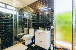 a bathroom with a toilet and a glass shower at Oaklands Tin Nest in Ruiru +12 photos