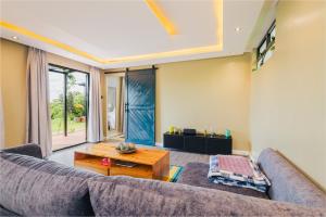 a living room with a couch and a table at Oaklands Tin Nest in Ruiru