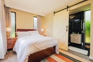 a bedroom with a bed and a sliding glass door at Oaklands Tin Nest in Ruiru