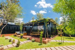 a gazebo with a picnic table in a garden at Oaklands Tin Nest in Ruiru