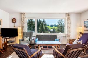 a living room filled with furniture and a large window at Haus Gutach in Schönwald