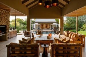 an outdoor living room with a fireplace and a patio at Ujima Lodge in Hoedspruit