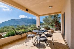 a patio with a table and chairs and a view of a mountain at La Dolce Rustica - Hillside Villa in Sutomore