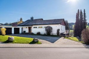 a large white house with a driveway at Haus Gutach in Schönwald
