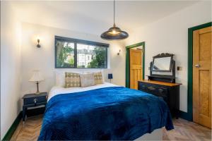 a bedroom with a bed and a tv and a window at Tawny Lodge in York