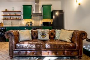 a brown leather couch in a kitchen with green cabinets at Tawny Lodge in York