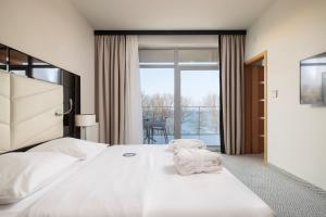 a bedroom with a large bed with towels on it at Diune Hotel by Zdrojowa in Kołobrzeg +97 photos